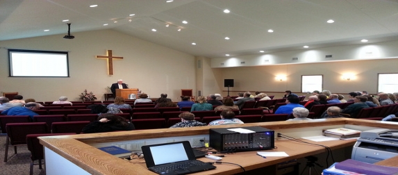 The auditorium from the back, with the congregation seated before the cross